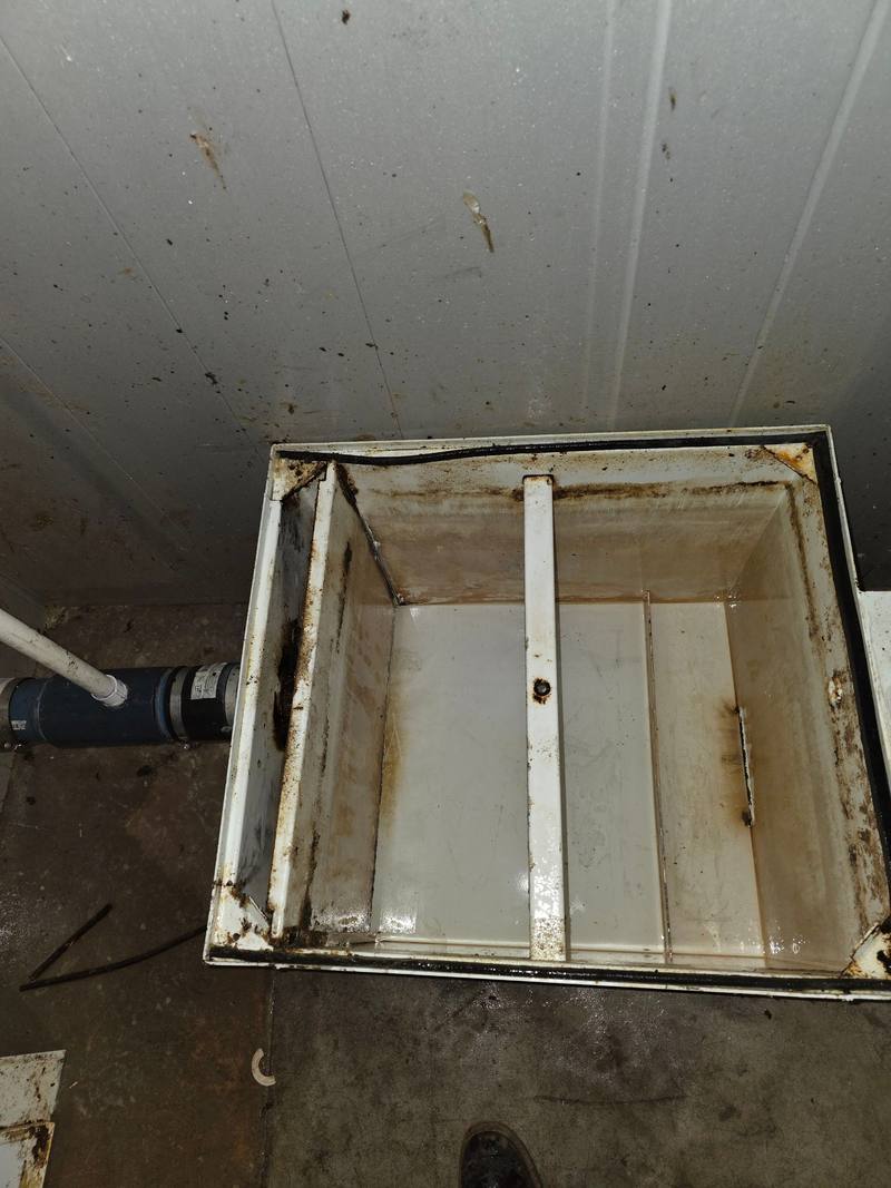 Grease interceptor box pumped empty, with its white walls and crossbars visible